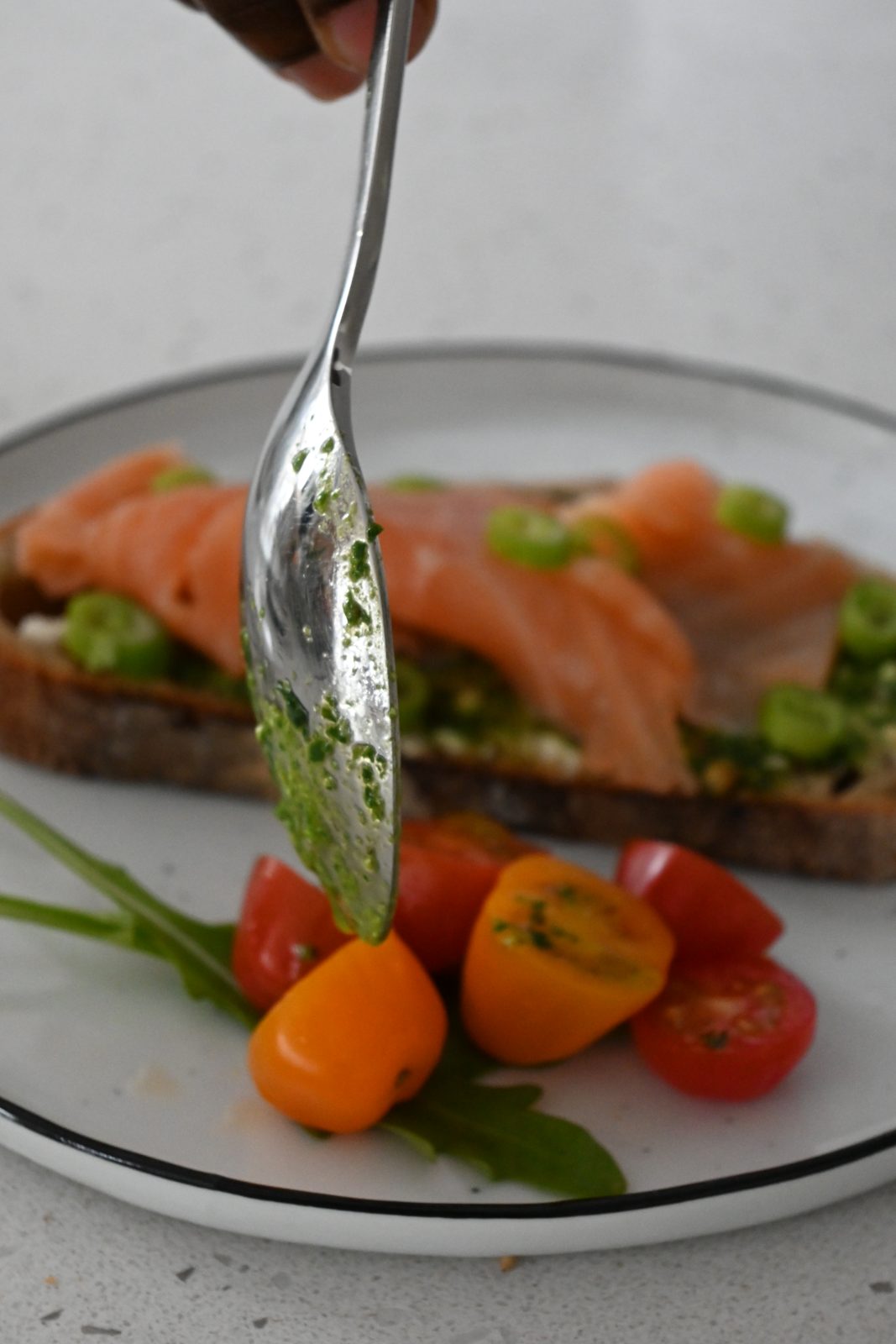 Tartine de saumon au pesto d'herbes, tomates cerises et roquette